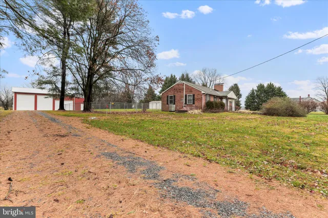 a view of an house with backyard and trees