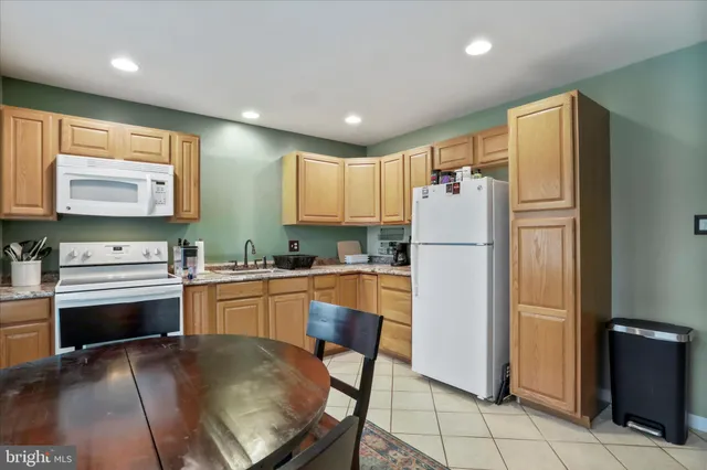 a kitchen with granite countertop a refrigerator stove top oven and sink