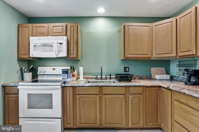 a kitchen with granite countertop cabinets stainless steel appliances and a sink