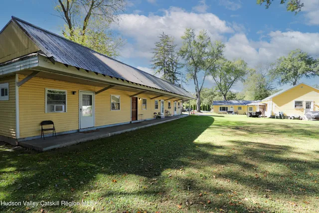 a view of a house with backyard and a tree