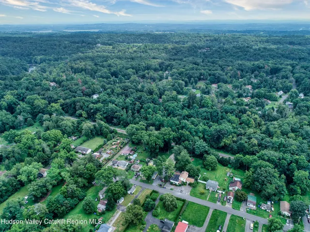 an aerial view of residential houses with outdoor space and trees