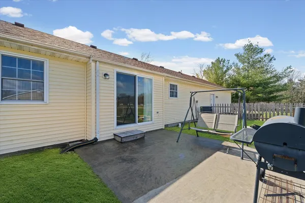 a view of backyard with chair and iron fence