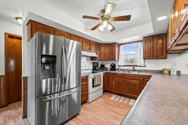 a kitchen with stainless steel appliances granite countertop a refrigerator a stove top oven a sink and dishwasher