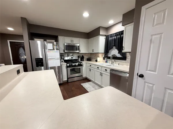 a kitchen with stainless steel appliances granite countertop a refrigerator sink and stove
