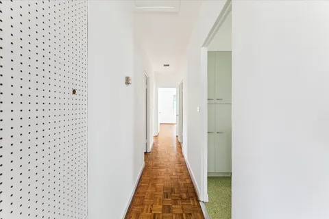 a view of a hallway with wooden floor