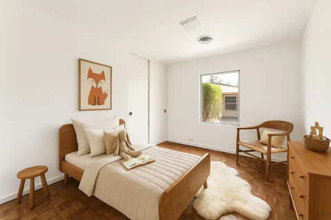 a bedroom with a bed and wooden floor