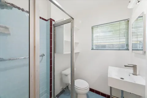 a bathroom with a toilet a sink and a large mirror