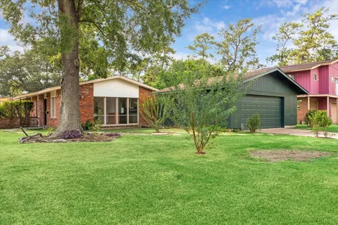 a view of a house with a backyard and a tree