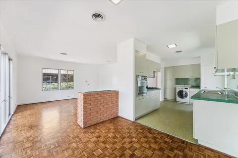 a living room with furniture and a open kitchen view