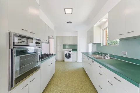 a kitchen with white cabinets and appliances