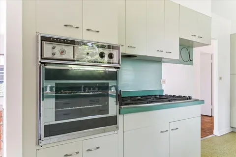 a kitchen with white cabinets and white appliances