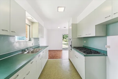 a kitchen with granite countertop a sink a stove and cabinets
