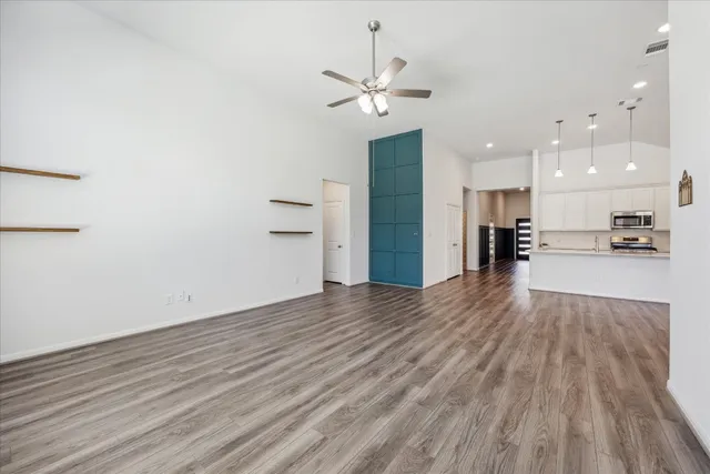 a view of an empty room and kitchen view