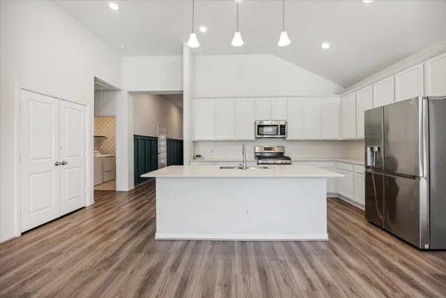 a kitchen with kitchen island a sink stainless steel appliances and cabinets