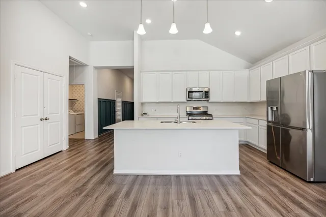 a kitchen with kitchen island a sink stainless steel appliances and cabinets