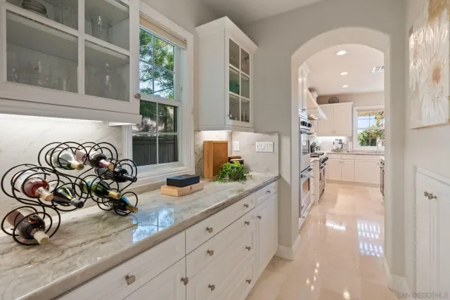 a kitchen with granite countertop white cabinets and white appliances
