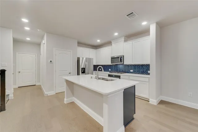 a kitchen with stainless steel appliances a sink stove and refrigerator