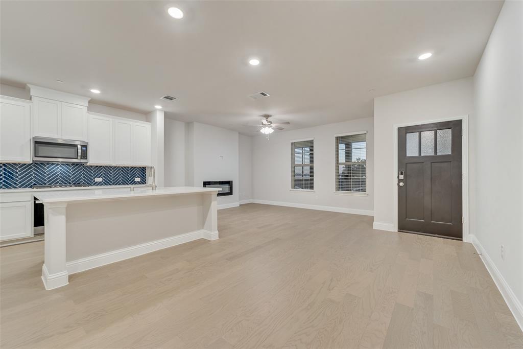 7853 Sunset Boulevard Rowlett, TX 75088 - Photo 6 of 31 a large white kitchen with kitchen island a refrigerator a sink dishwasher with a stove and white cabinets