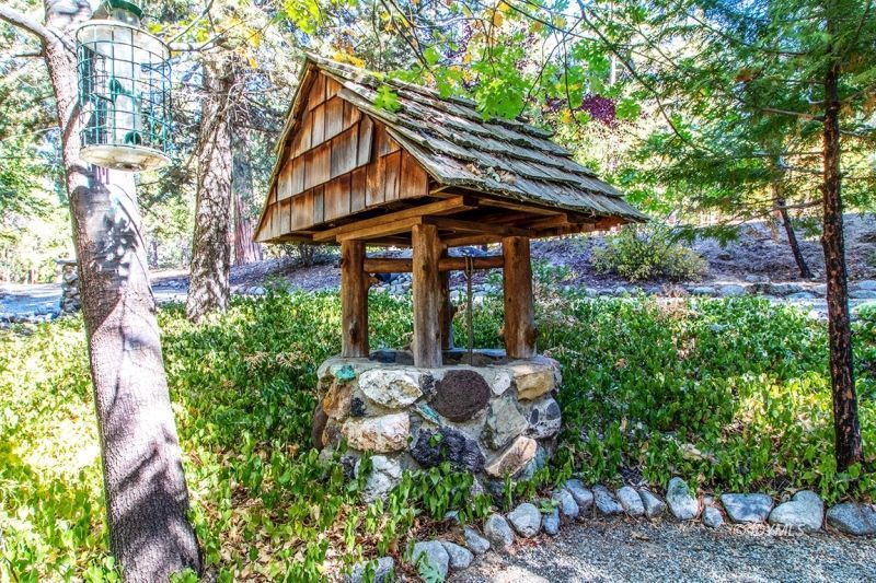 27401 Saunders Meadow Road Idyllwild, CA 92549 - Photo 9 of 37 a backyard of a house with table and chairs under an umbrella