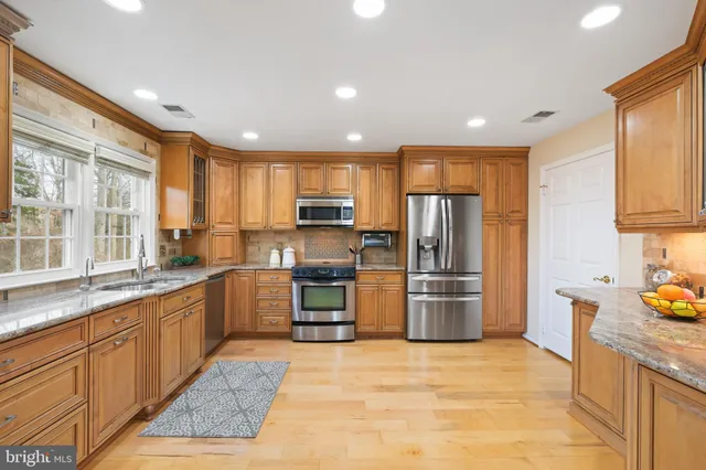 a kitchen with stainless steel appliances granite countertop a refrigerator sink and stove