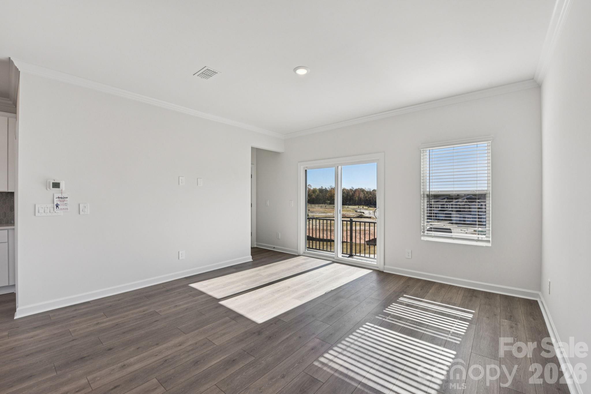 323 Golden Maple Court Fort Mill, SC 29708 - Photo 5 of 22 a view of an empty room with a window and wooden floor