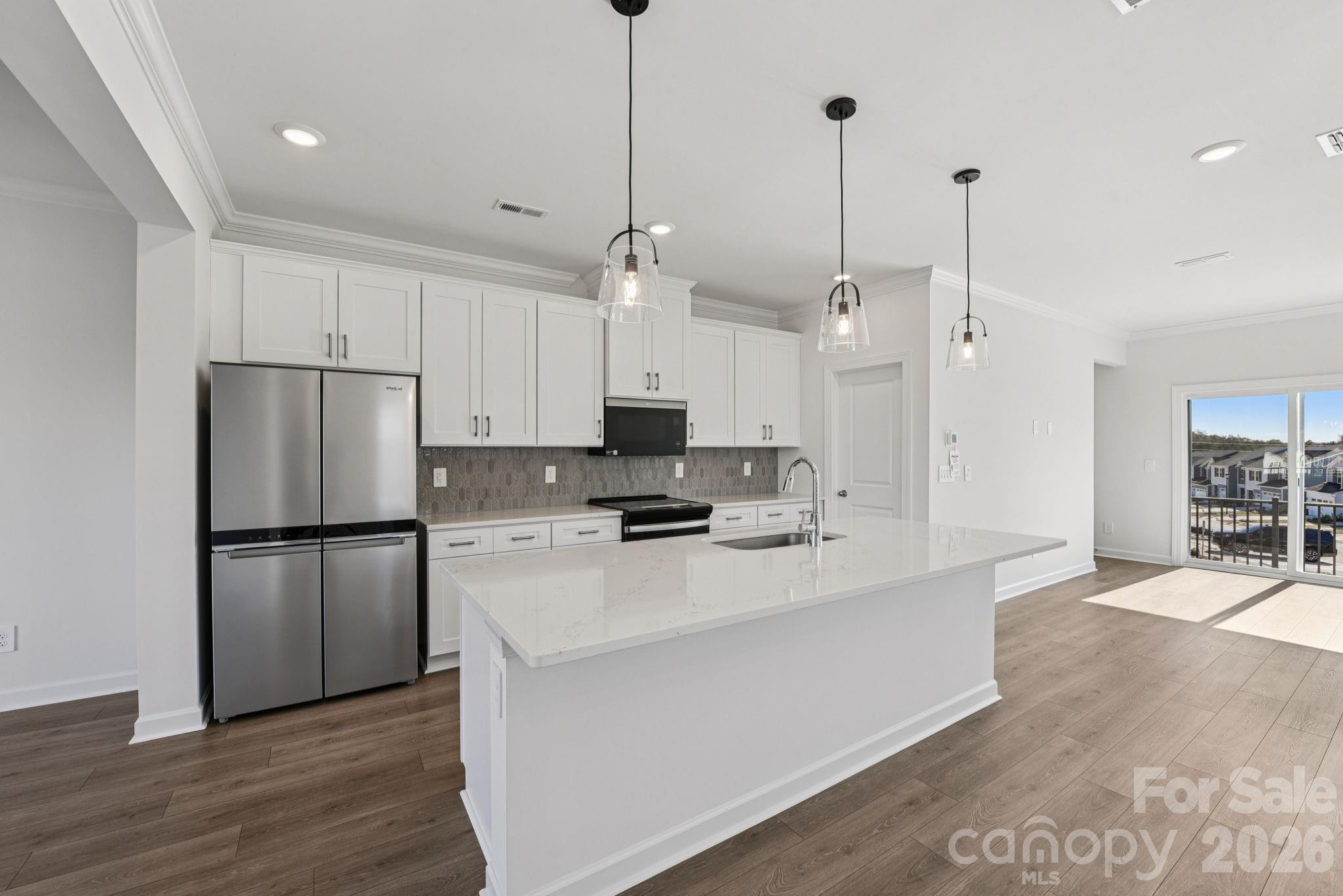 323 Golden Maple Court Fort Mill, SC 29708 - Photo 7 of 22 a kitchen with kitchen island a stove a refrigerator a sink and a oven with wooden floor