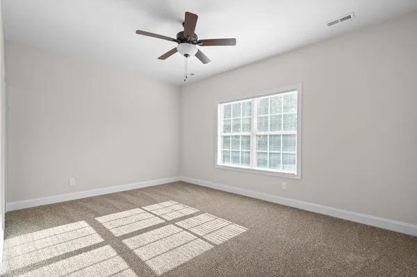 an empty room with a window and a fan