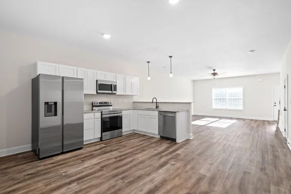 a large kitchen with stainless steel appliances granite countertop a stove a sink and a refrigerator