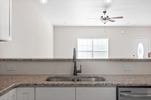 a view of a kitchen sink granite counter tops and a wooden floor