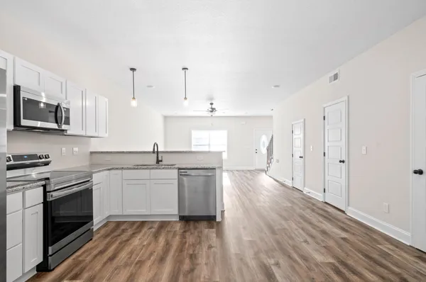 a kitchen with stainless steel appliances granite countertop a sink stove and microwave