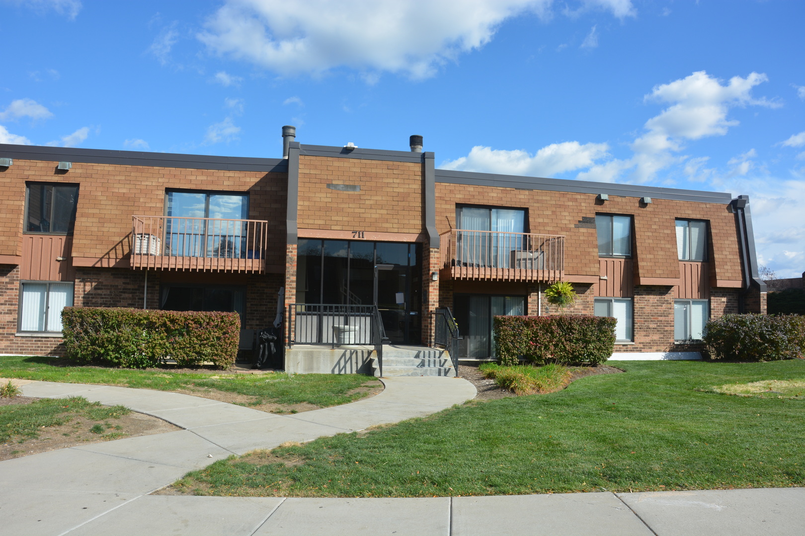 a front view of a house with a yard and trees
