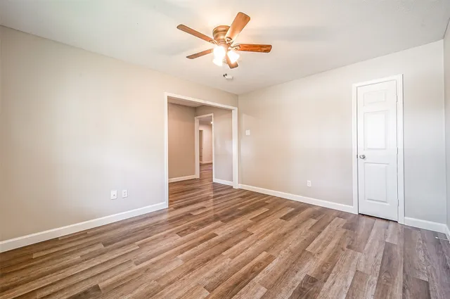 wooden floor in an empty room with a fan