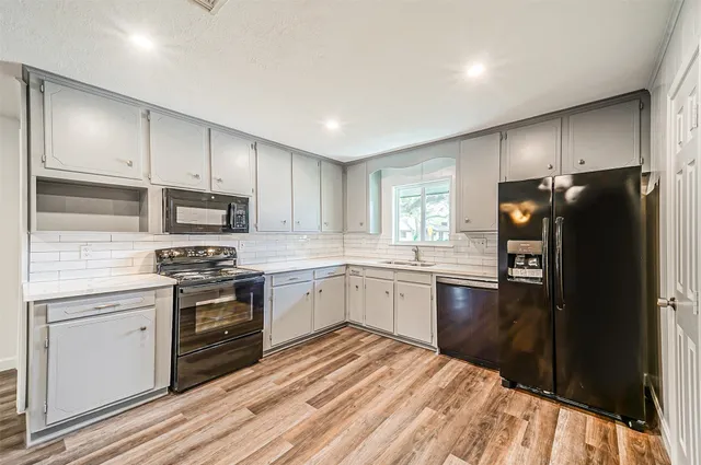 a kitchen with granite countertop a refrigerator stove top oven and sink
