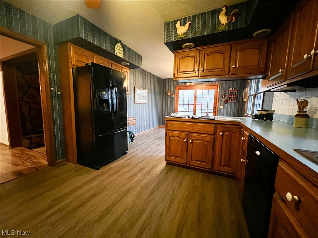 10263 Cemetery Road Burbank, OH 44214 - Photo 4 of 22 Kitchen with black appliances, tasteful backsplash, light hardwood / wood-style floors, and kitchen peninsula