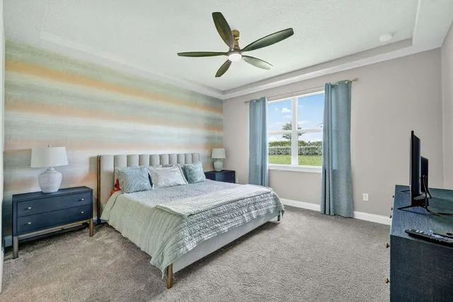 a bedroom with a bed and a large window