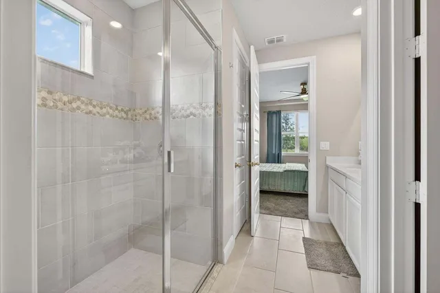 a bathroom with a glass shower door and a bathroom