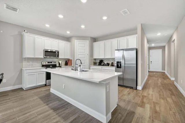 a kitchen with stainless steel appliances a refrigerator stove microwave and sink