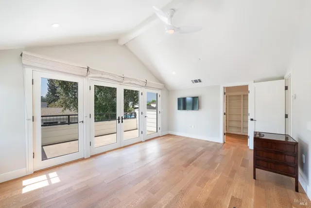 a view of a big room with wooden floor and windows