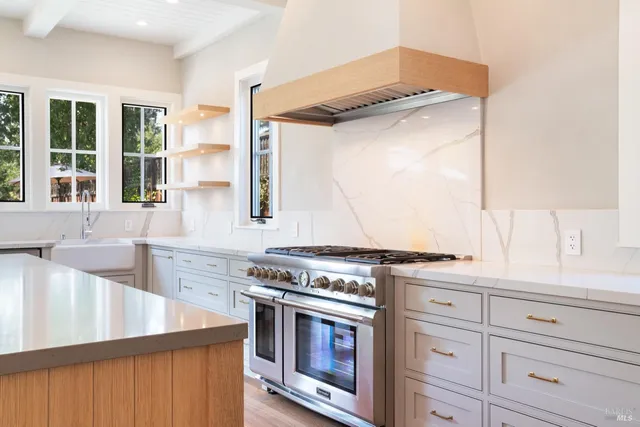 a kitchen with stainless steel appliances granite countertop a stove and a sink with granite countertops