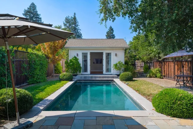 a view of swimming pool with a lounge chairs in a patio