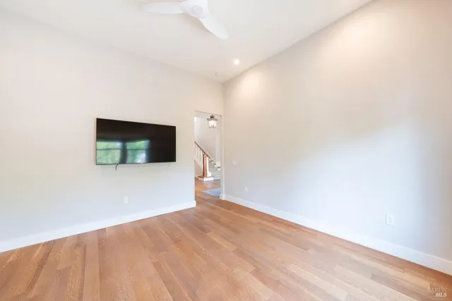 a view of empty room with wooden floor