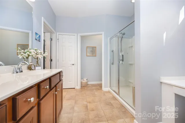 a bathroom with a granite countertop sink a mirror and a shower