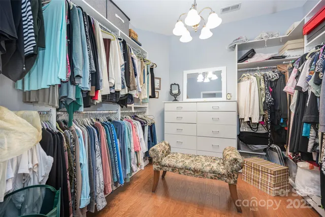 a view of walk in closet with clothes and shoes