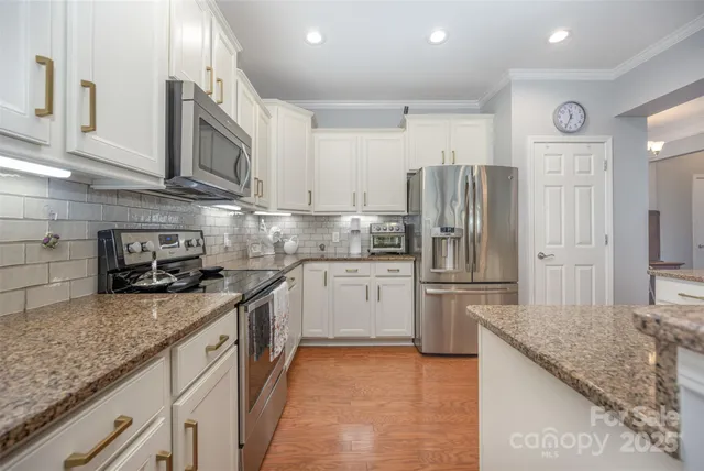 a kitchen with stainless steel appliances granite countertop a refrigerator sink and cabinets