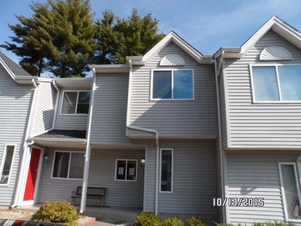 155 Redstone Hill Road, Unit 62 Bristol, CT 06010 - Photo 1 of 1 a view of a white house with large windows and a small yard