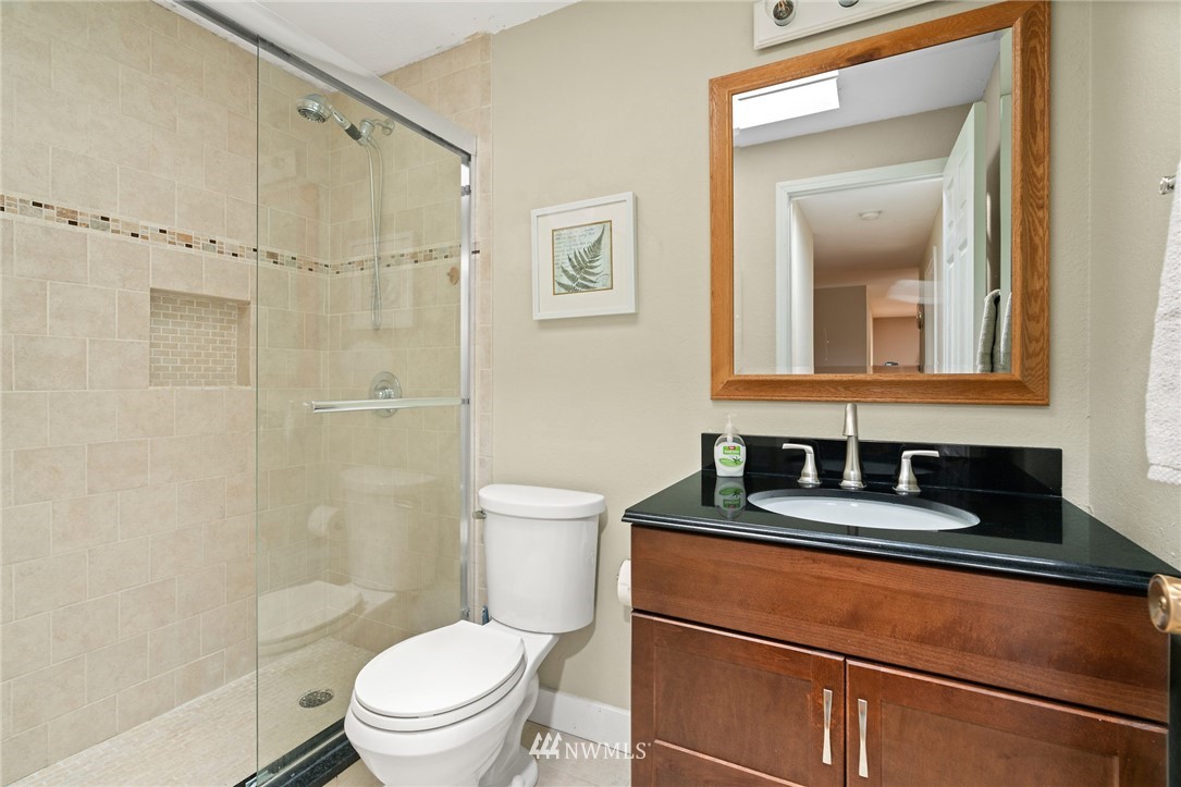 2312 168th Street Southeast Bothell, WA 98012 - Photo 14 of 29 a bathroom with a granite countertop sink toilet a mirror and shower