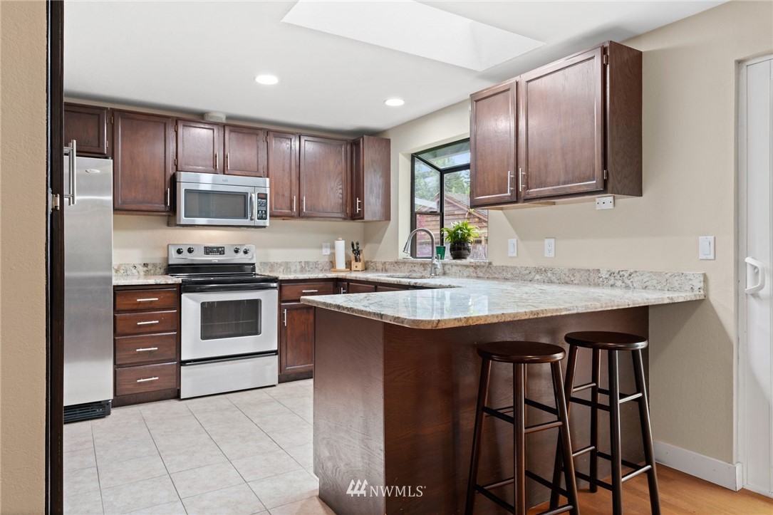 2312 168th Street Southeast Bothell, WA 98012 - Photo 6 of 29 a kitchen with stainless steel appliances granite countertop a stove top oven a sink and dishwasher