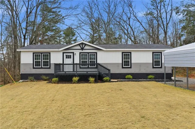 a view of a house with a yard and large tree