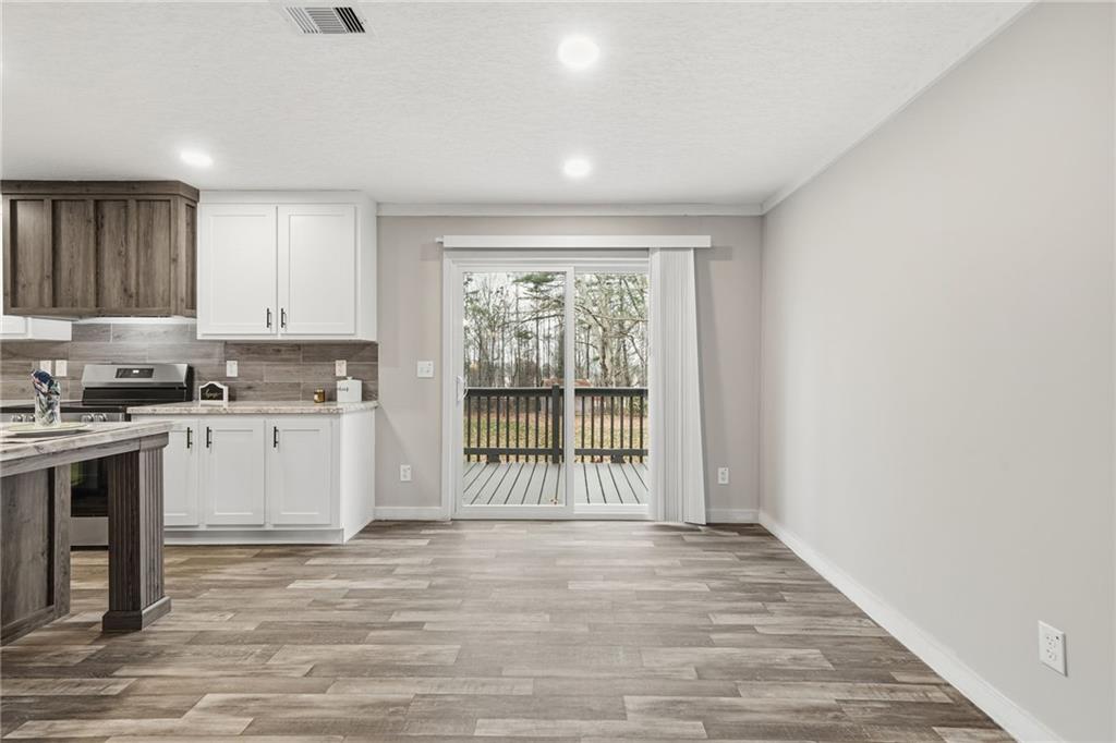 239 Fairview Road Ball Ground, GA 30107 - Photo 26 of 41 a view of a kitchen with a sink and dishwasher with wooden floor