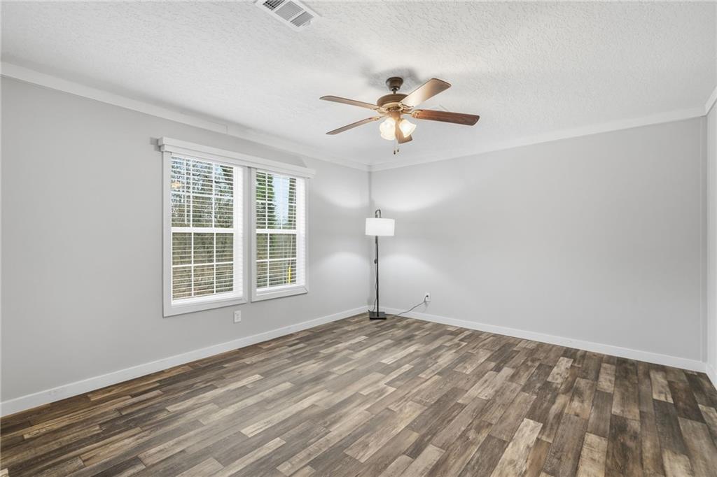 239 Fairview Road Ball Ground, GA 30107 - Photo 29 of 41 a view of empty room with wooden floor and fan
